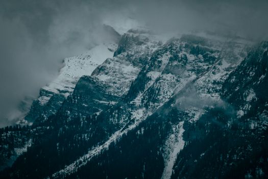 薄雾笼罩着白雪皑皑的山峰，景色令人惊叹，完美捕捉了冬季的精髓