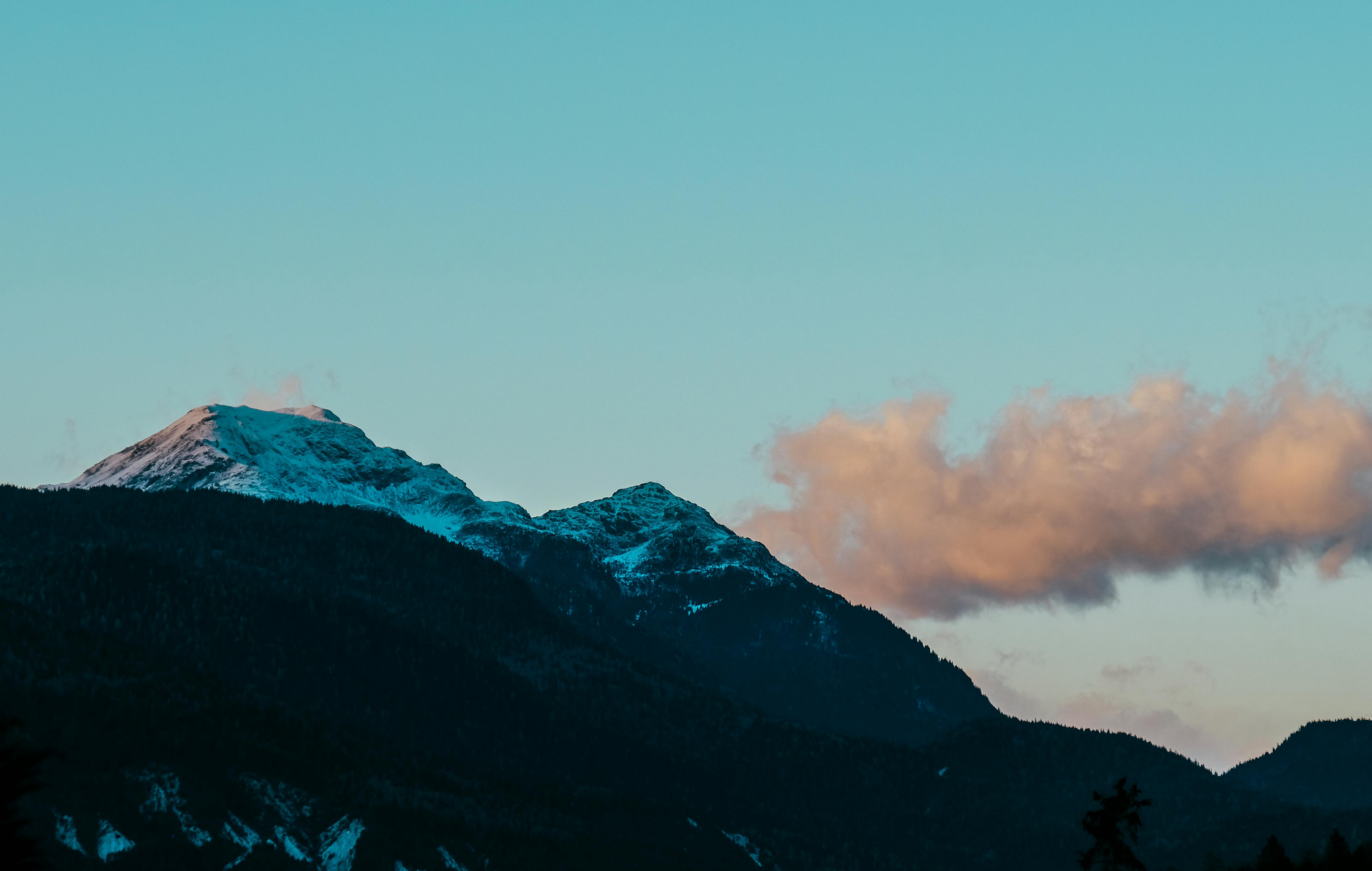 日出时分，柔和的天空映衬着白雪皑皑的山峰