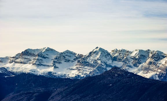 Breathtaking view of a snow-covered mountain range under a clear sky, perfect for winter adventures.