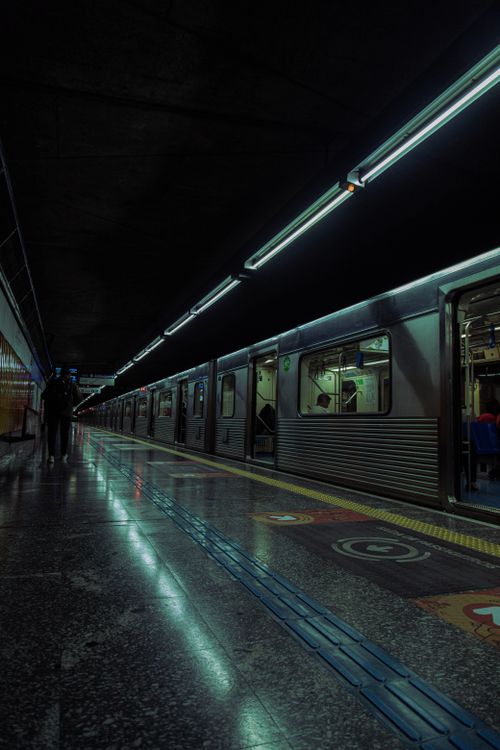 Free A dark, moody subway station with a train ready for departure, capturing urban transit atmosphere. Stock Photo