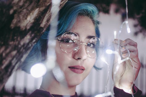 Free Photo of Woman in Sunglasses Holding String Lights Stock Photo