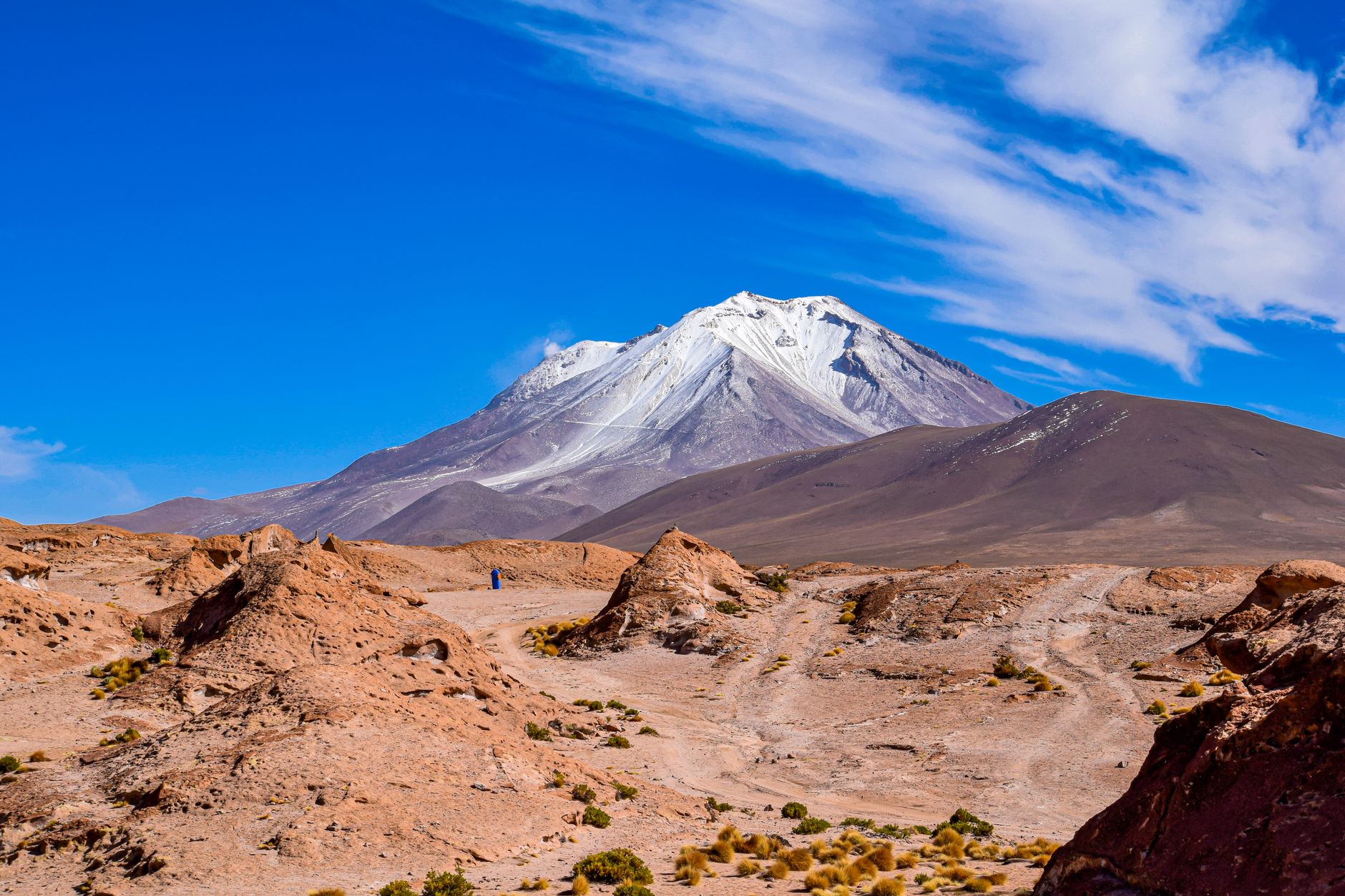 Sunlit landscape of the Andes with majestic mountains and vibrant blue skies.