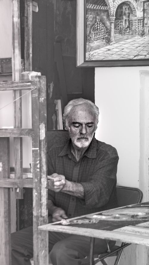 Free Elderly man sitting in a Puebla studio, engaged in thoughtful creativity. Stock Photo