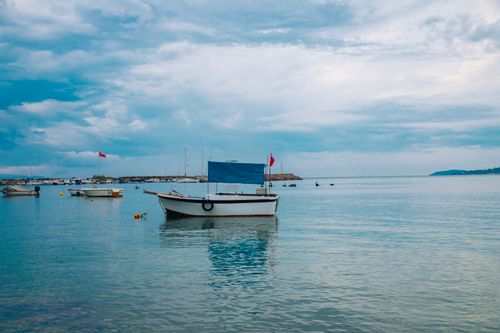 Free Tranquil seascape of boats on the calm Çandarli coast in İzmir, Türkiye. Stock Photo