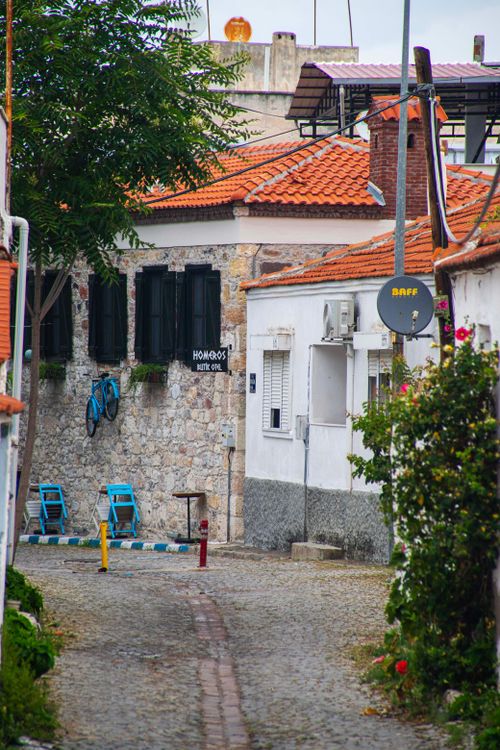 Free Explore a quaint cobblestone street in Çandarli, featuring traditional architecture and vibrant colors. Stock Photo