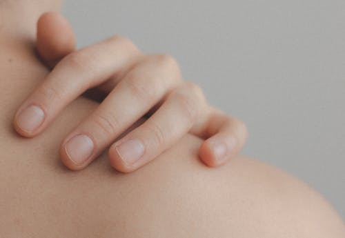 Close-up Photo of Person Touching their Shoulder