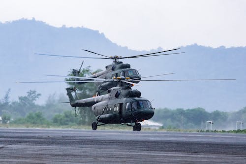 Military commando helicopters landing on asphalt ground