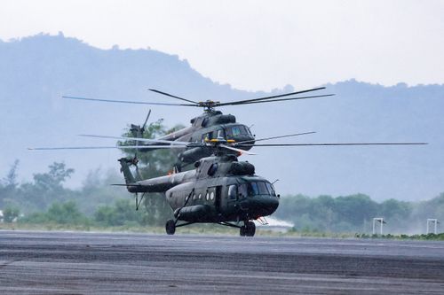 Free Modern armed military helicopters landing on asphalt ground against rocky hills in countryside on daytime Stock Photo