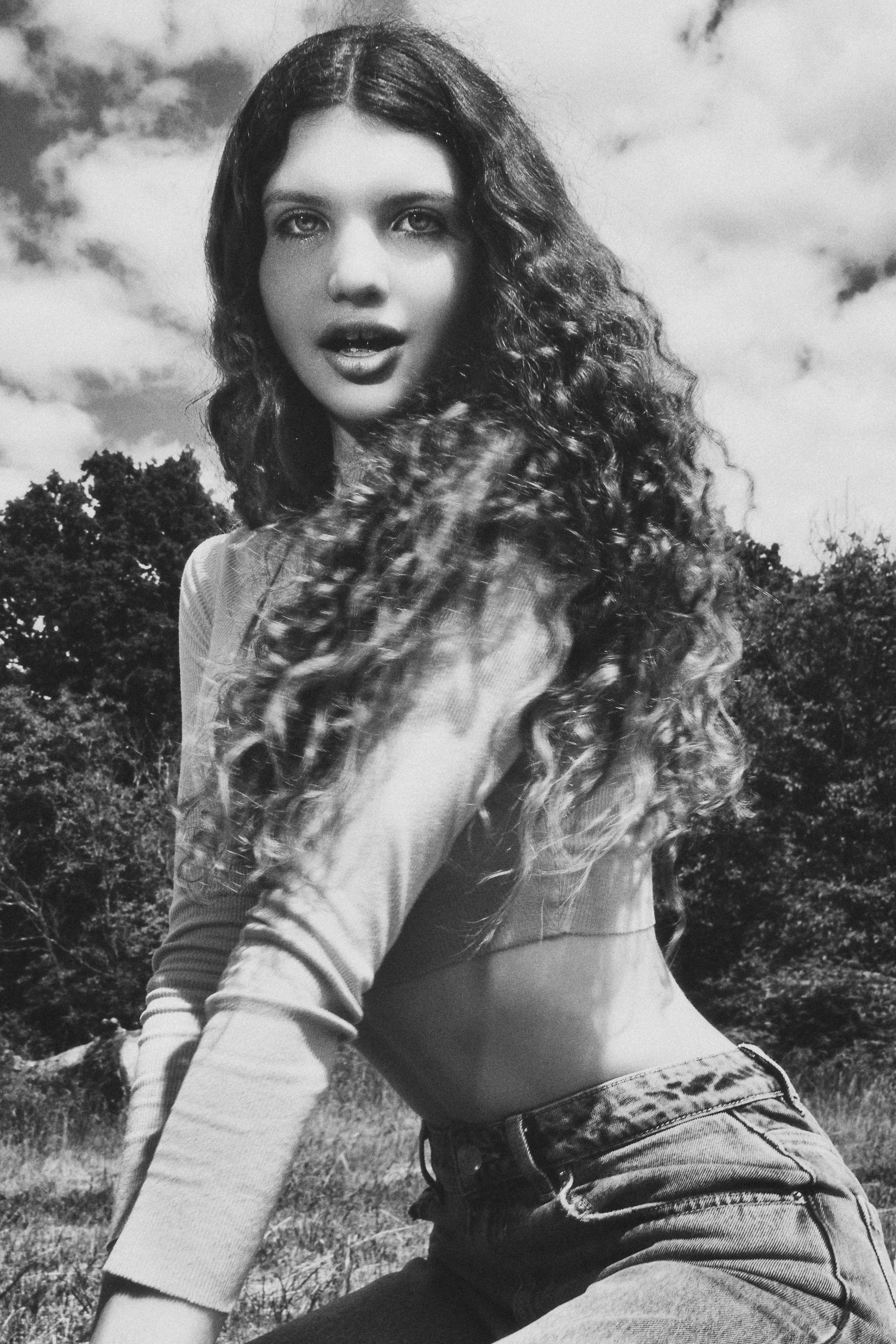 Woman with Curly Hair Posing in Black and White · Free Stock Photo