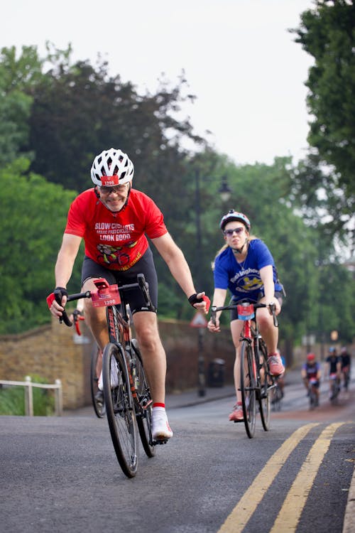 Two people riding bicycles down a road