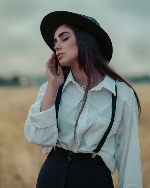 Portrait of Brunette Woman in Hat and White Shirt