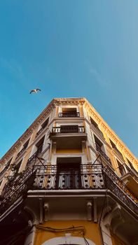 Low angle view of a traditional building with balconies against a clear blue sky.