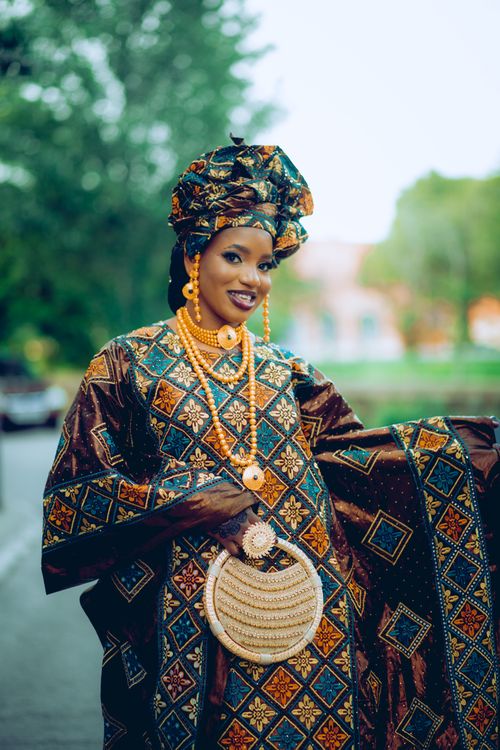 Free Young woman in colorful traditional African dress smiling outdoors, showcasing cultural fashion. Stock Photo