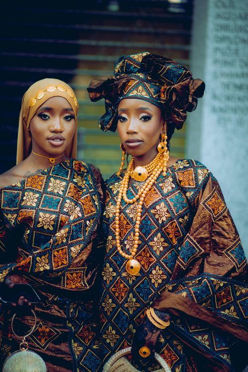 Free Two women in colorful traditional African gowns and headscarves posing gracefully. Stock Photo