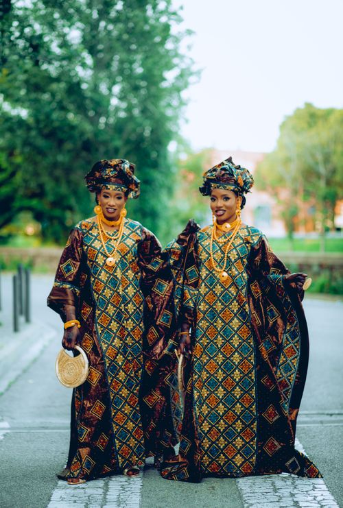 Free Two women in colorful traditional African dresses posing outdoors, smiling warmly. Stock Photo