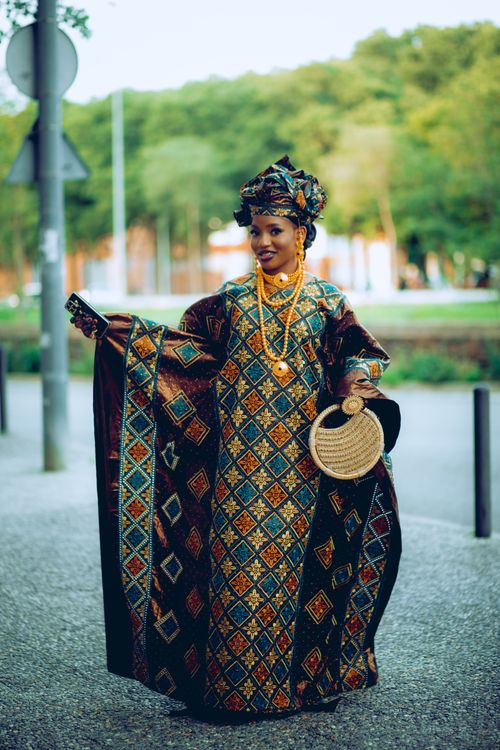 Free Beautiful African woman in traditional attire posing outdoors with vibrant dress and accessories. Stock Photo