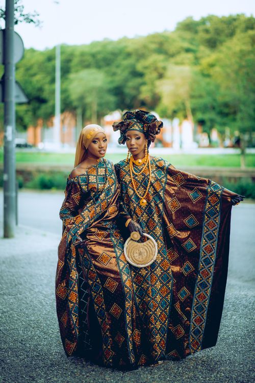 Free Two African women in vibrant traditional clothing, posing elegantly outdoors. Captures cultural heritage. Stock Photo