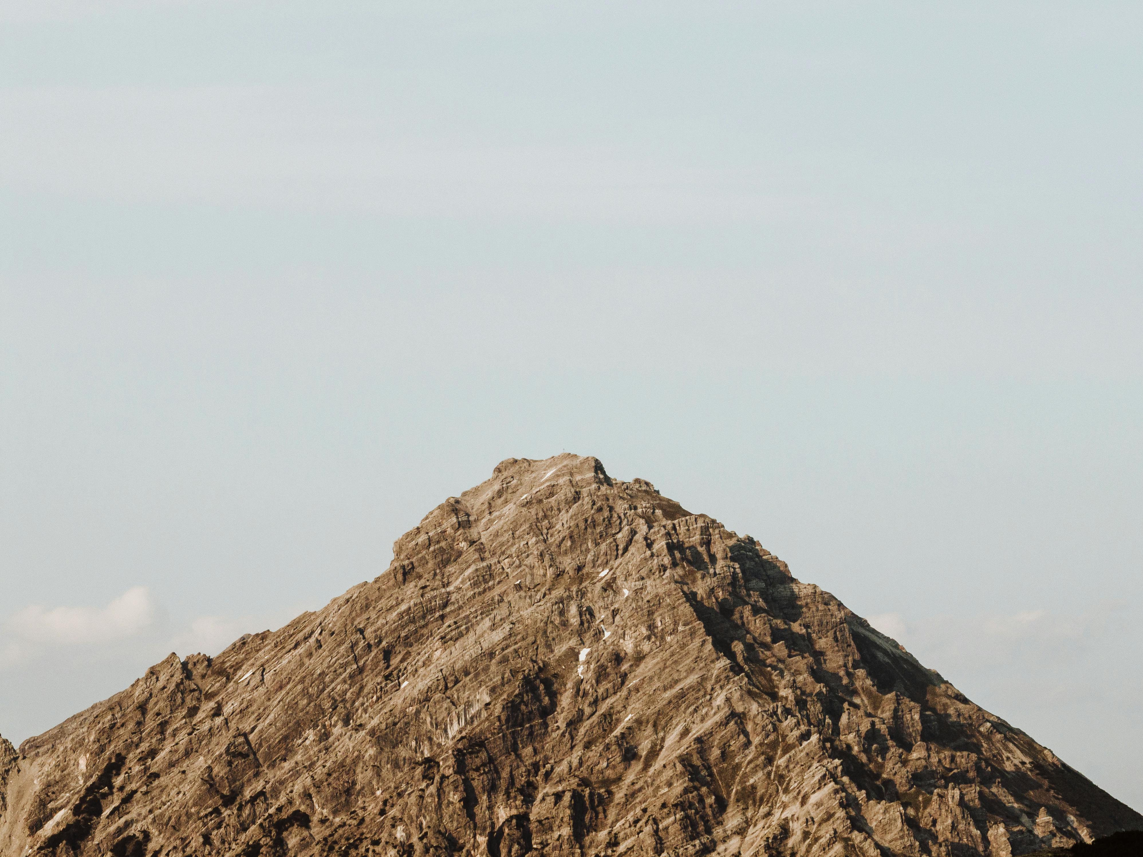 Breathtaking view of a rugged mountain peak in Malbun, Liechtenstein, under a clear sky.