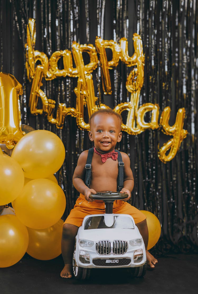 Smiling Boy On Toy Car At Birthday 