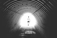 在瑞士贝尔瓦尔德，一名男子的剪影走过一条明亮的隧道，照片以黑白色拍摄