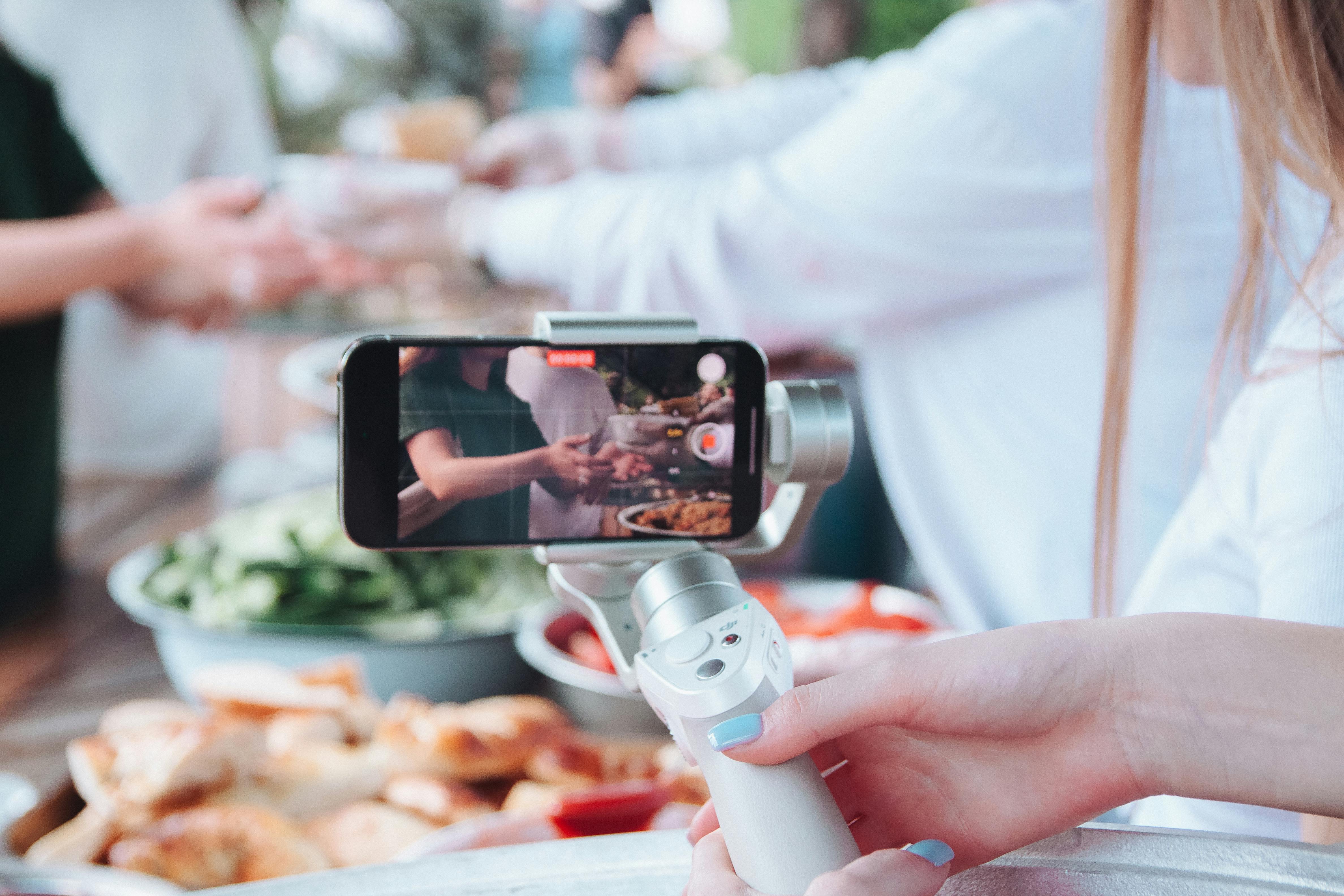 woman hand holding tripod and recording video with smartphone