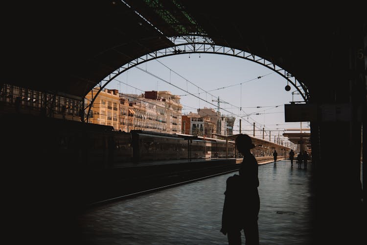 Silhouettes Of Travelers Waiting At The Train Station