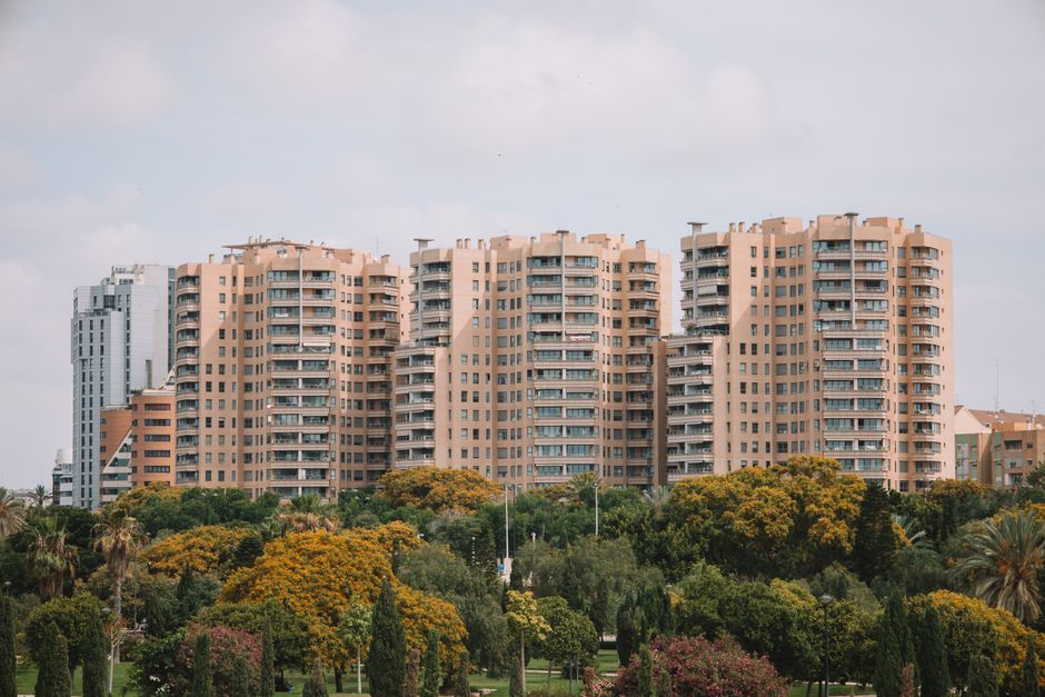 Edificios residenciales en Valencia, España, con exuberante vegetación en primer plano.