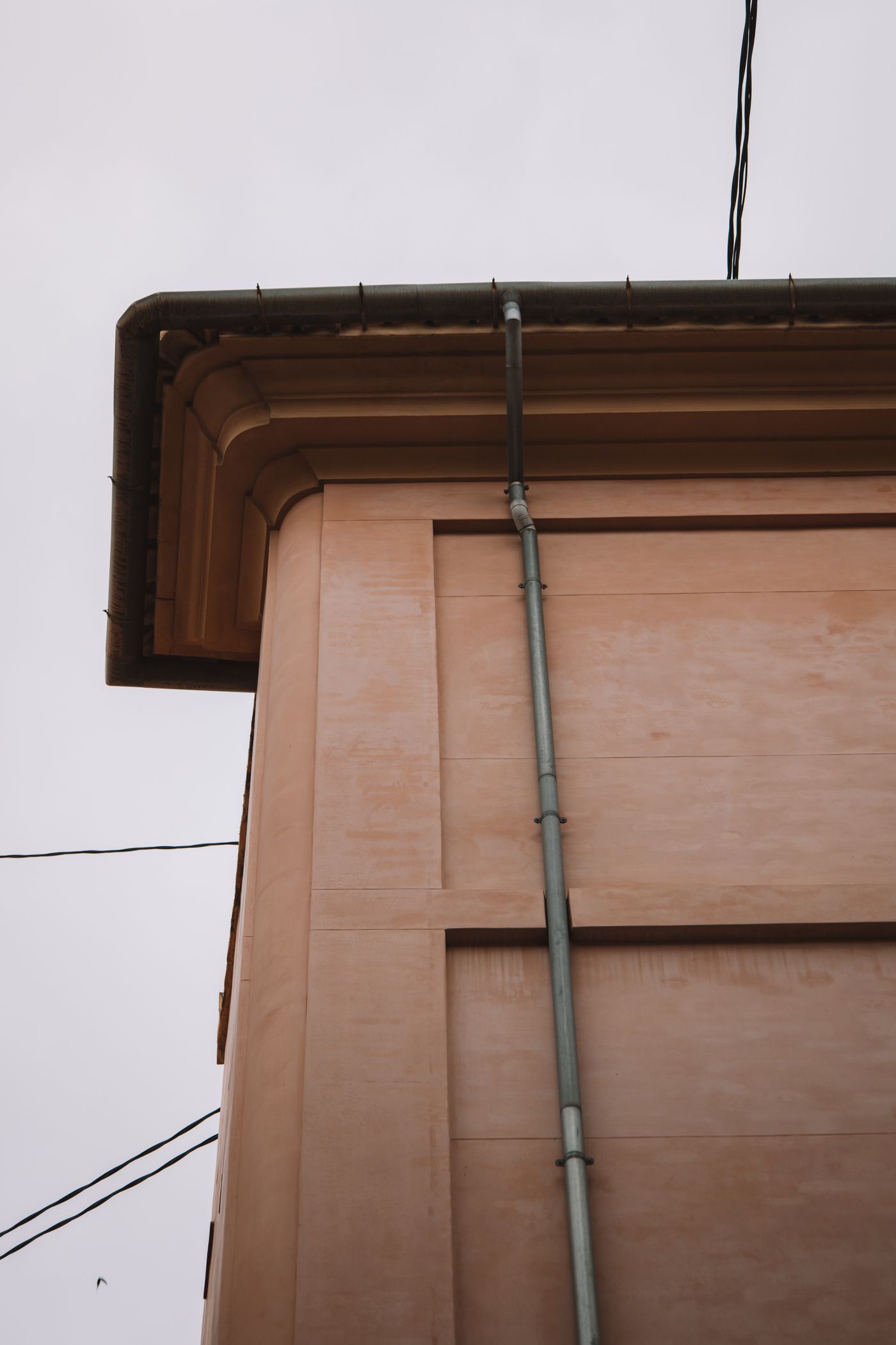 An overhanging roof and downpipe seen from below