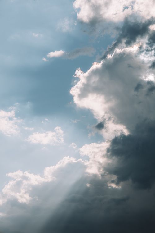 Free Soft sunlight filters through dramatic clouds over Valencia, Spain, in a serene sky view. Stock Photo