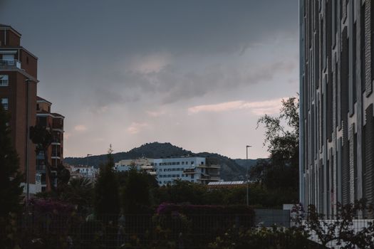 A view of apartment buildings and hills under an overcast sky in Valencia, Spain.