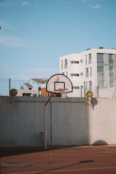Basketball court in urban Valencia, Spain, under a clear summer sky.