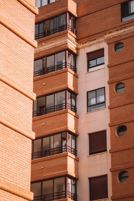 Detailed view of Valencia residential brick building facade showcasing urban architecture.