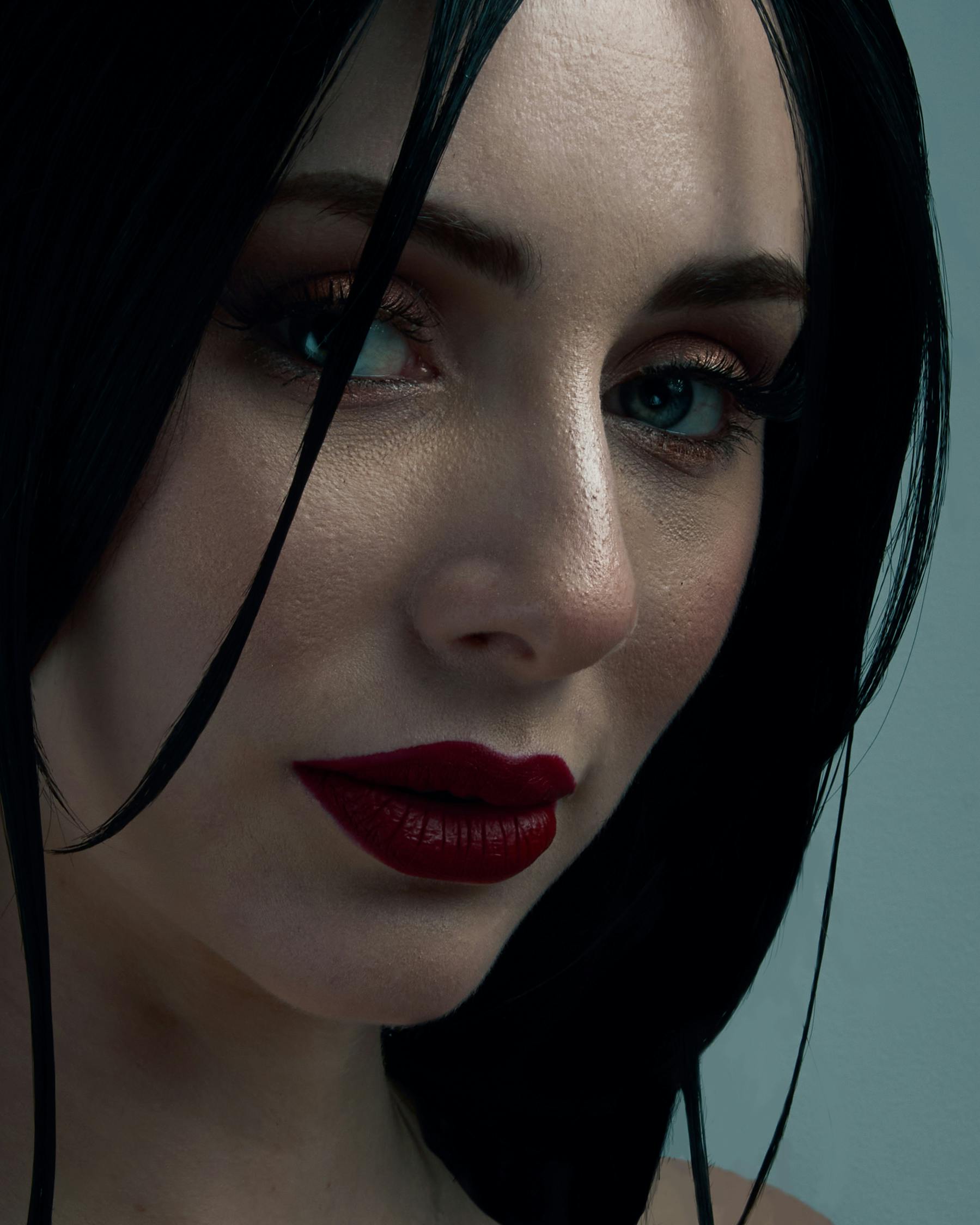 Free Close-up portrait of a stylish woman with dark hair and red lipstick, showcasing fashion and elegance. Stock Photo