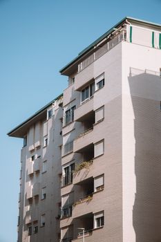 A contemporary residential building with balconies under a clear blue sky.