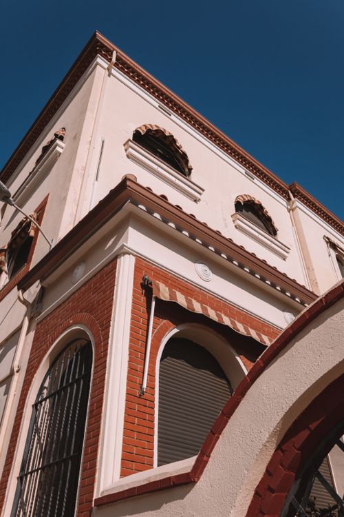 Free Low angle view of a beautiful urban building facade against a clear blue sky. Stock Photo