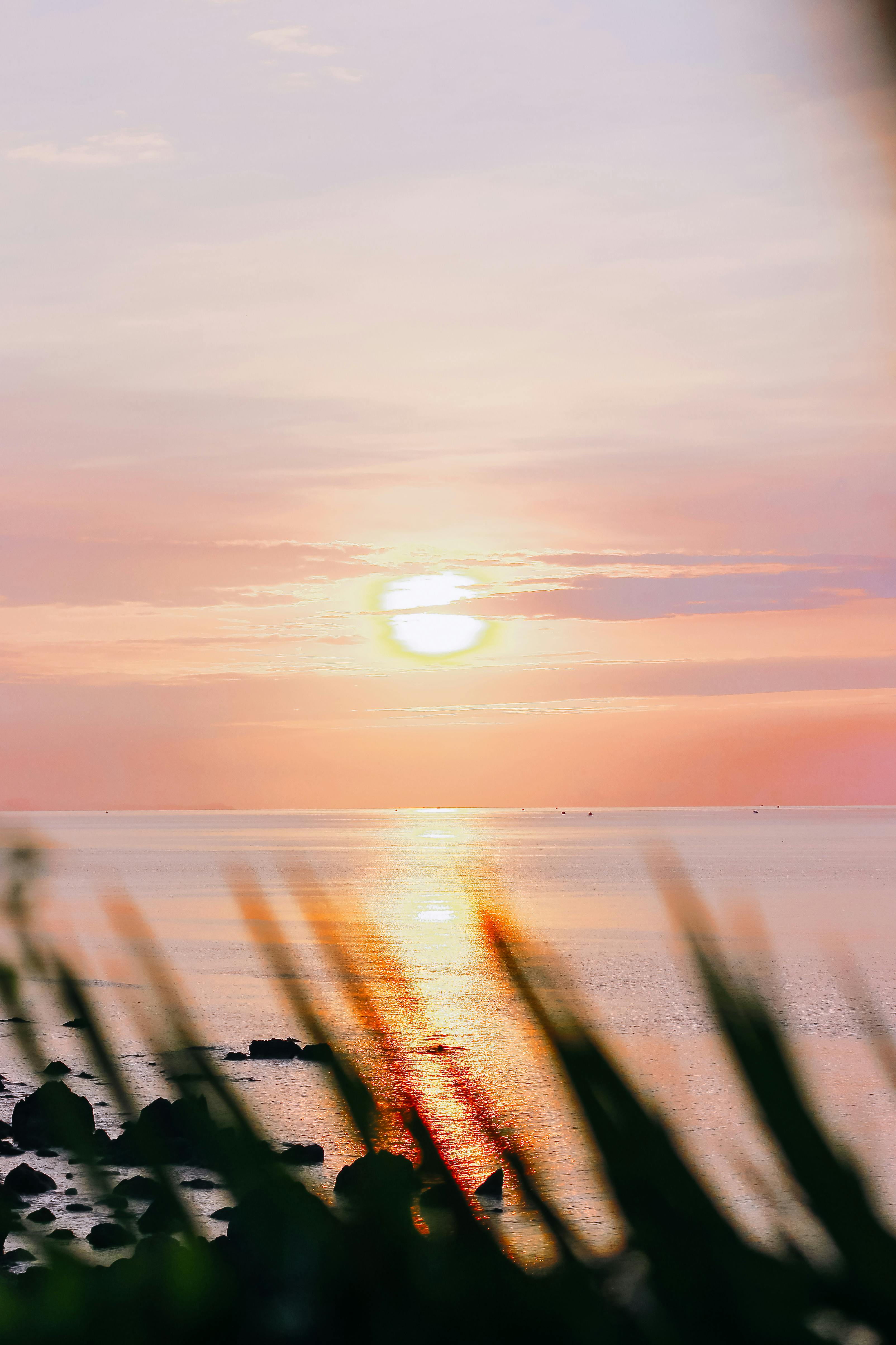Serene ocean sunset with vivid sky and tranquil sea reflecting warm hues.