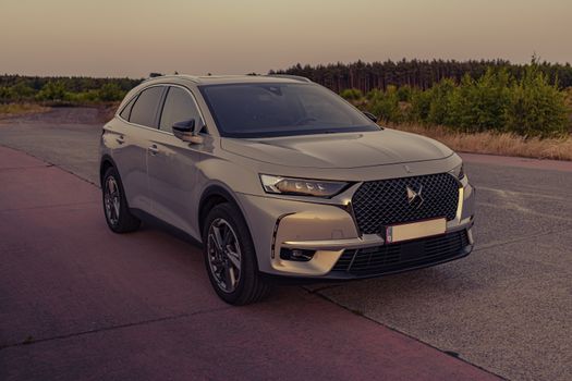 A sleek DS SUV parked on a rural road during dusk, showcasing luxury and elegance.
