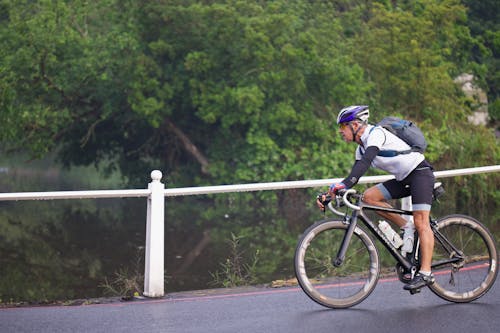 A man riding a bike on a road near a river