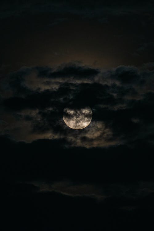 Free Close-up of a Full Moon behind Clouds  Stock Photo