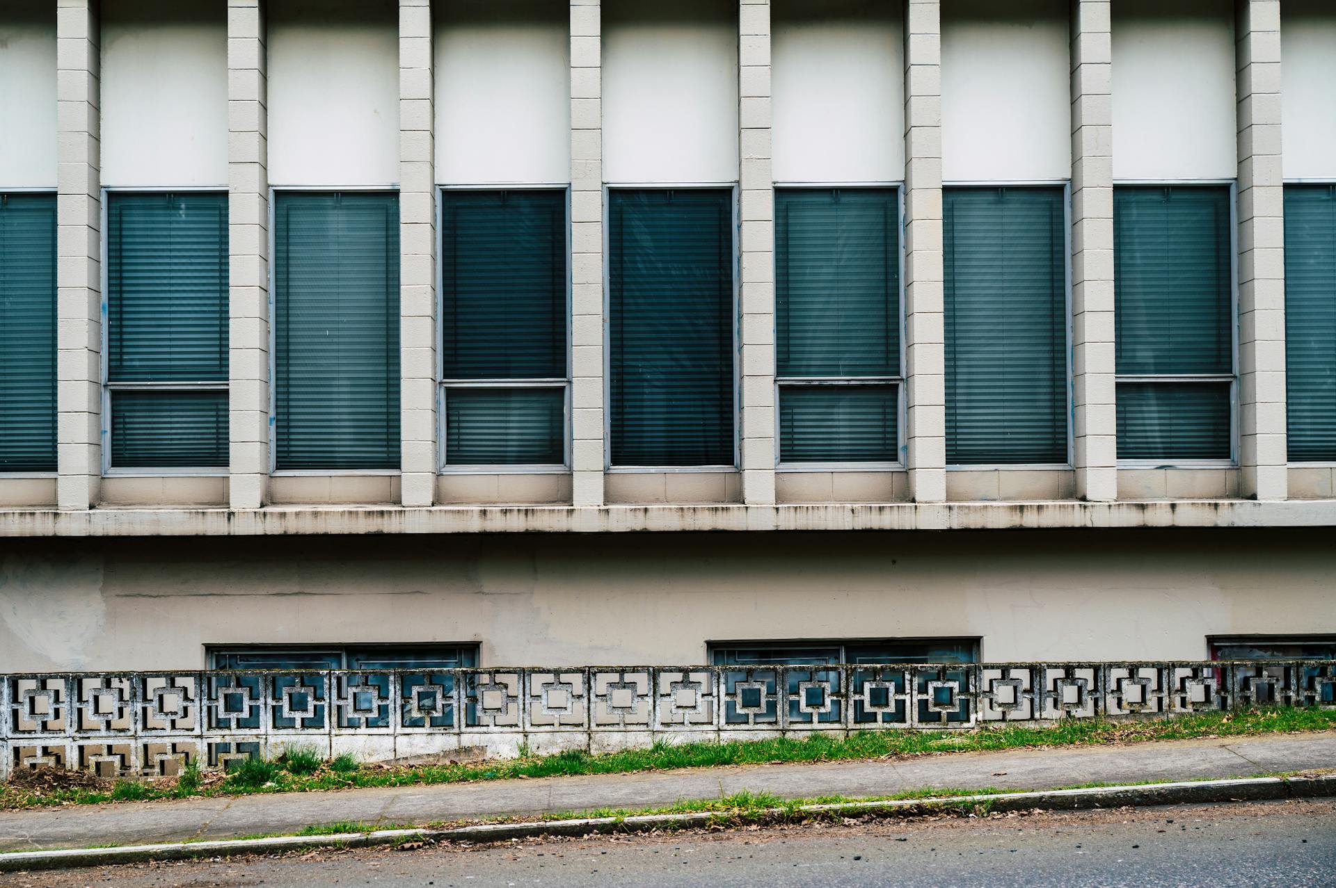 Explore the decaying urban architecture of an abandoned office building with neglected windows and industrial design.