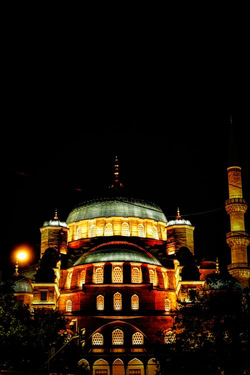 Free A beautifully illuminated mosque with a shining dome and minaret at night, symbolizing Islamic architecture. Stock Photo