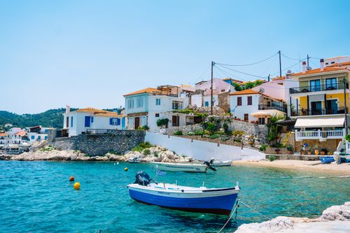 Free Charming Greek coastal village with colorful houses and boats on a sunny summer day. Stock Photo