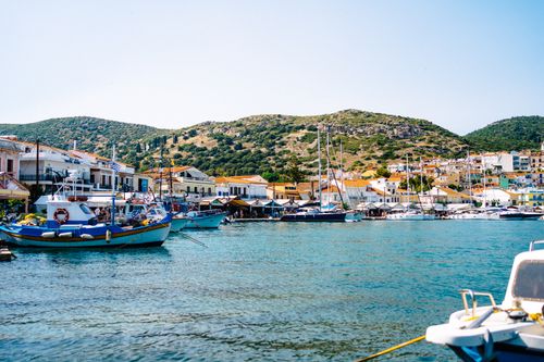 Free Colorful coastal village with boats moored by the sea on a sunny day. Stock Photo