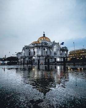 Reflective night view of Palacio de Bellas Artes in Mexico City, highlighting its iconic architecture.