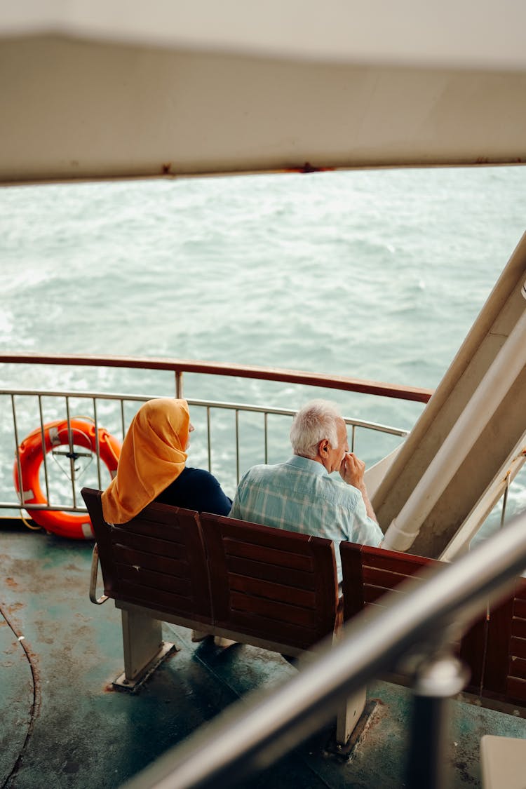 An Elderly Couple Sitting On A Branch On The Boat