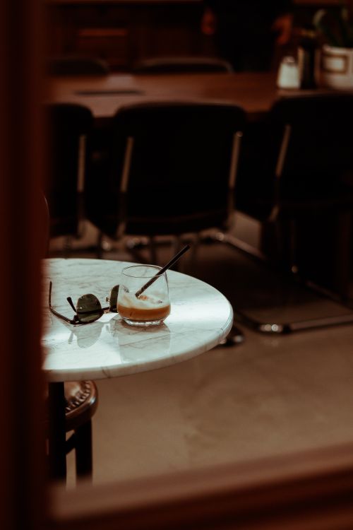 Free Stylish drink with sunglasses on a marble table in an Ankara café, capturing an urban lifestyle vibe. Stock Photo