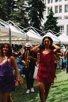 Vibrant outdoor festival with dancing women and live saxophone music in Ankara, Türkiye.