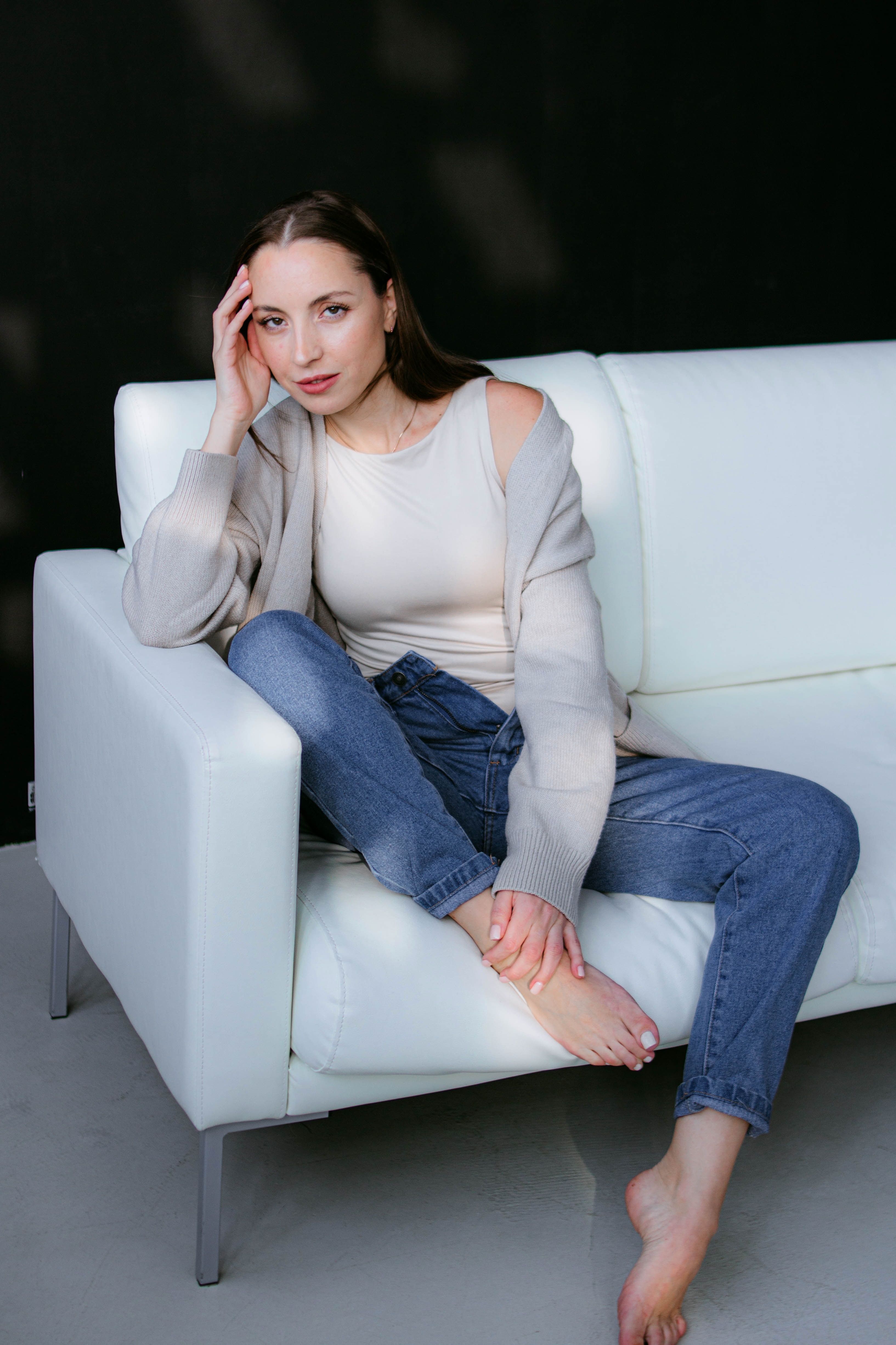 Woman wearing a bronze cami and brown cardigan with jeans