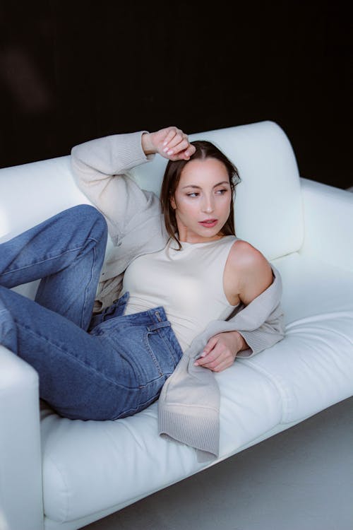 A Woman Posing on a White Sofa