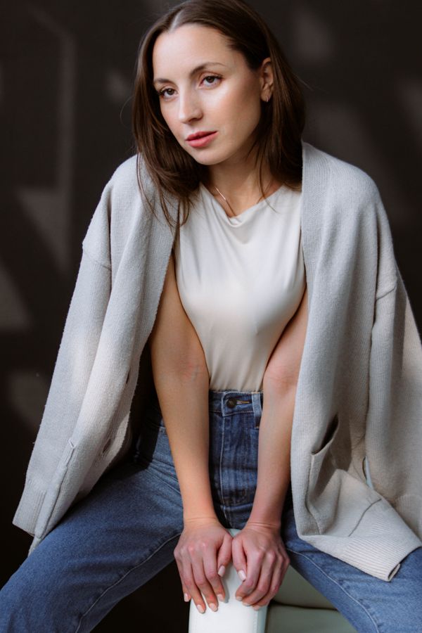Woman wearing a toffee cardigan set with straight-leg jeans